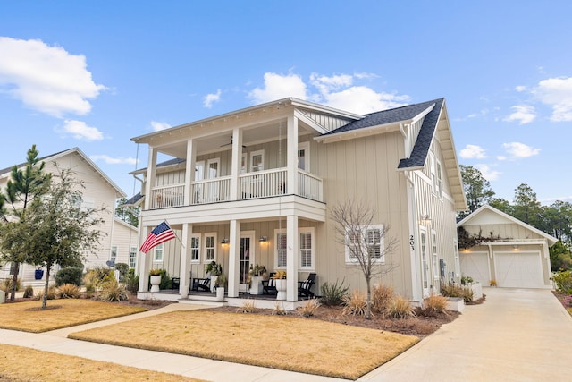 view of front of house with a balcony, covered porch, an outbuilding, a garage, and a front lawn