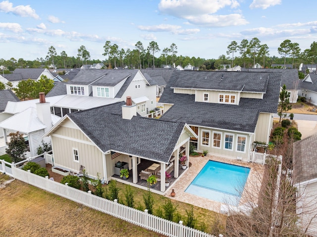 rear view of property with a fenced in pool and a patio area