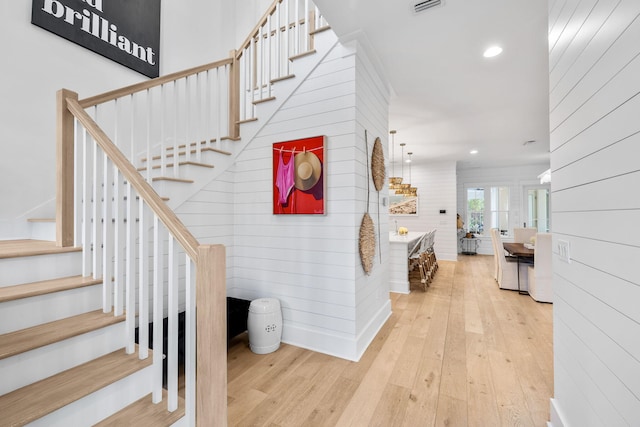 stairway with hardwood / wood-style flooring and wooden walls