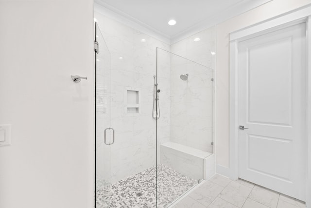 bathroom featuring crown molding and a shower with shower door