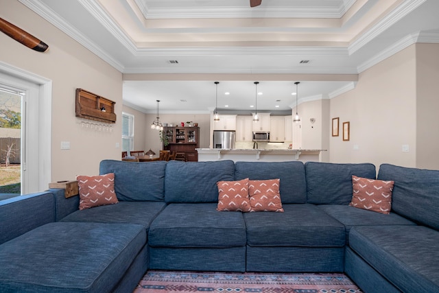 living room with crown molding, a raised ceiling, and a wealth of natural light