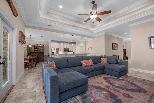 living room featuring a raised ceiling, crown molding, and ceiling fan