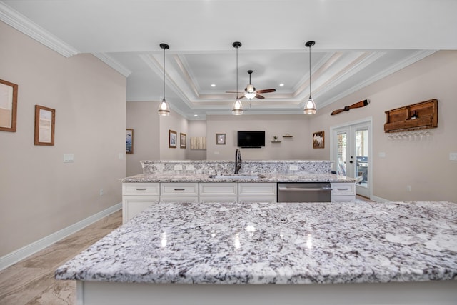 kitchen featuring pendant lighting, sink, dishwasher, white cabinetry, and a tray ceiling