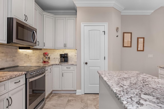 kitchen with white cabinetry, appliances with stainless steel finishes, crown molding, and light stone counters