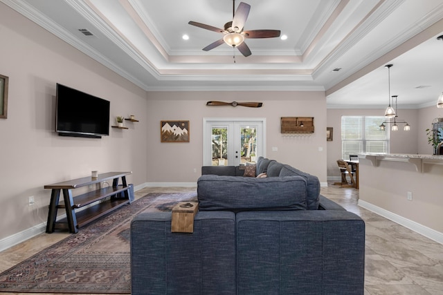 living room with french doors, ceiling fan, ornamental molding, and a tray ceiling