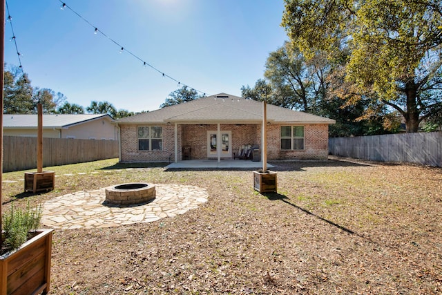 rear view of house featuring french doors, a patio, and an outdoor fire pit