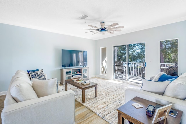 living room featuring crown molding, ceiling fan, and light wood-type flooring