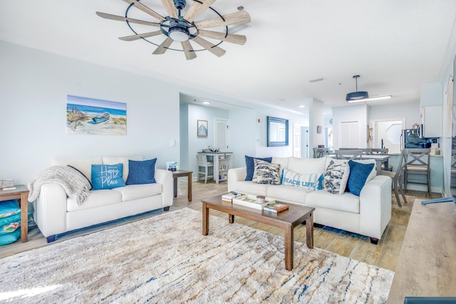 living room featuring ceiling fan and light hardwood / wood-style floors