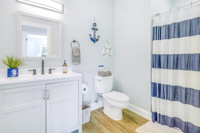 bathroom with walk in shower, vanity, toilet, and hardwood / wood-style floors