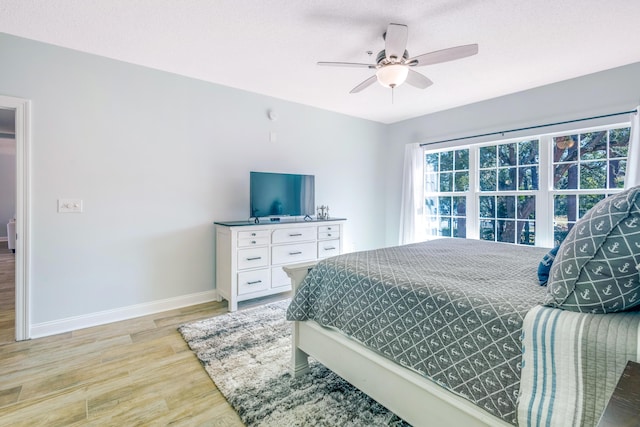 bedroom featuring a textured ceiling, ceiling fan, and light wood-type flooring