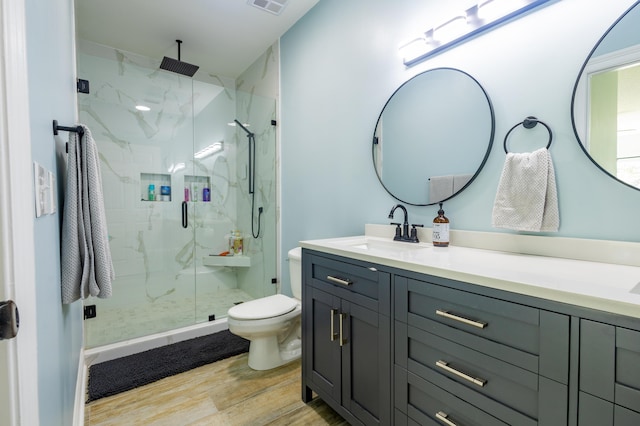 bathroom with vanity, hardwood / wood-style flooring, a shower with door, and toilet