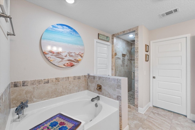 1911 Ladybird Ln, Gulf Breeze, FL 32563 - bathroom with baseboards, a textured ceiling, a stall shower, visible vents, and a bath