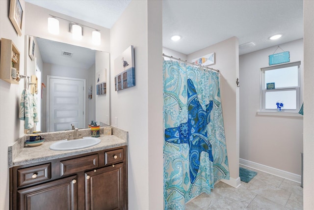 1911 Ladybird Ln, Gulf Breeze, FL 32563 - bathroom with vanity, baseboards, a textured ceiling, visible vents, and curtained shower