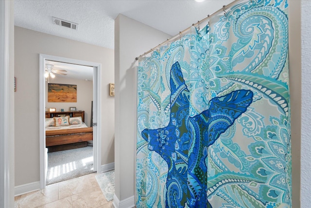 1911 Ladybird Ln, Gulf Breeze, FL 32563 - ensuite bathroom with connected bathroom, a ceiling fan, a textured ceiling, tile patterned flooring, and visible vents
