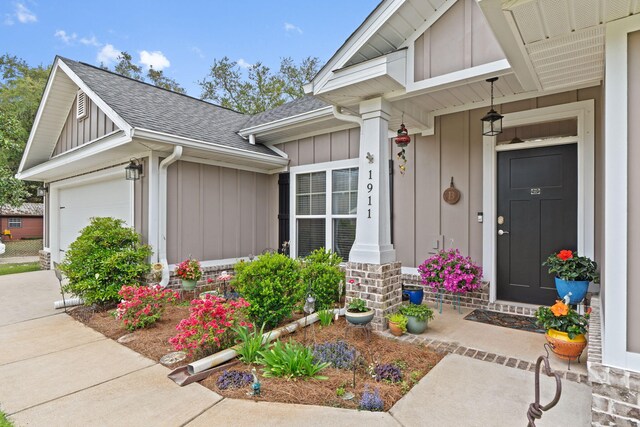 1911 Ladybird Ln, Gulf Breeze, FL 32563 - entrance to property featuring covered porch, an attached garage, board and batten siding, driveway, and a shingled roof