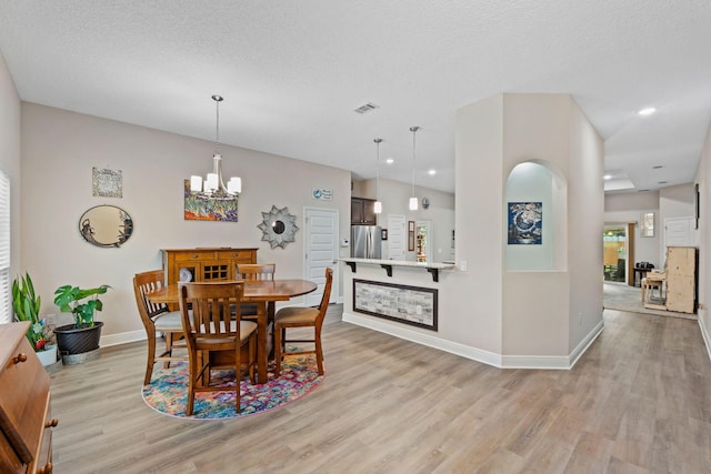 1911 Ladybird Ln, Gulf Breeze, FL 32563 - dining space featuring visible vents, a notable chandelier, light wood-style flooring, and a textured ceiling