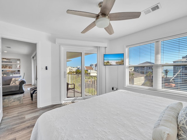 bedroom featuring wood-type flooring, access to exterior, and ceiling fan