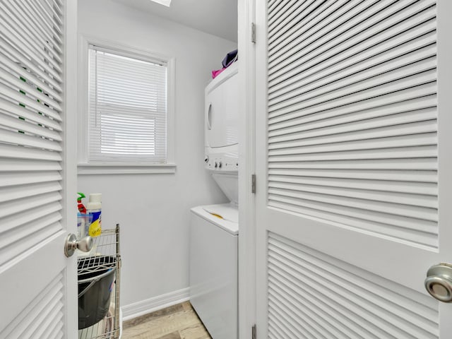 washroom with stacked washer / drying machine and light hardwood / wood-style floors