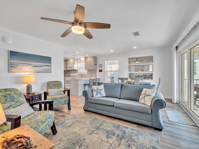 living room with ceiling fan and light hardwood / wood-style floors