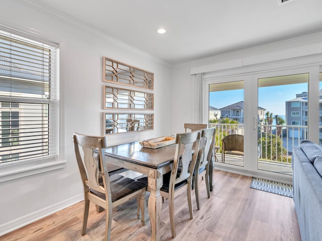 dining room featuring crown molding and light hardwood / wood-style flooring