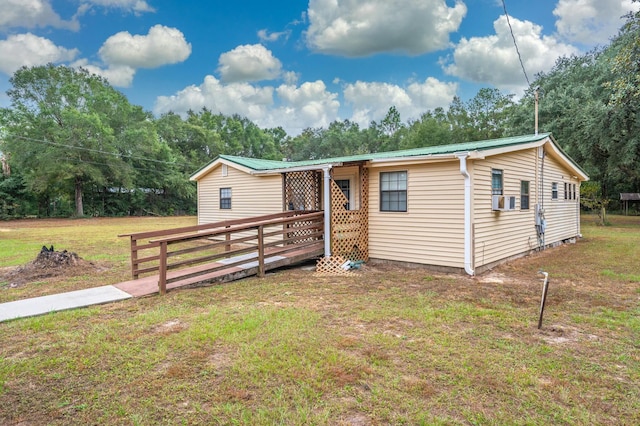 manufactured / mobile home with a wooden deck and a front lawn