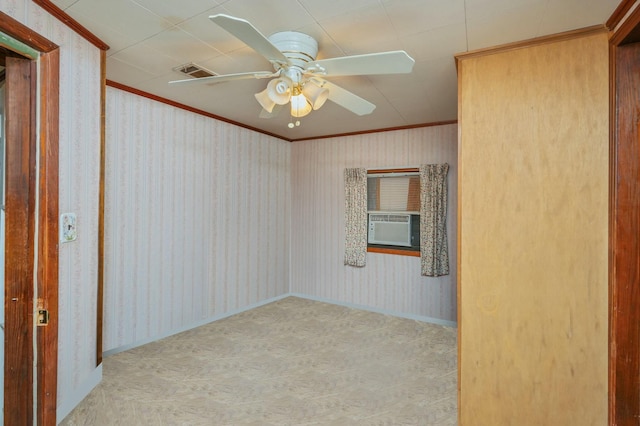 empty room featuring ornamental molding, cooling unit, light colored carpet, and ceiling fan