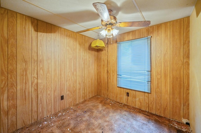 empty room with ceiling fan and wood walls