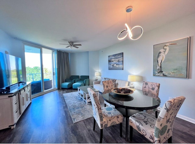 dining area with dark wood-type flooring, baseboards, and ceiling fan with notable chandelier