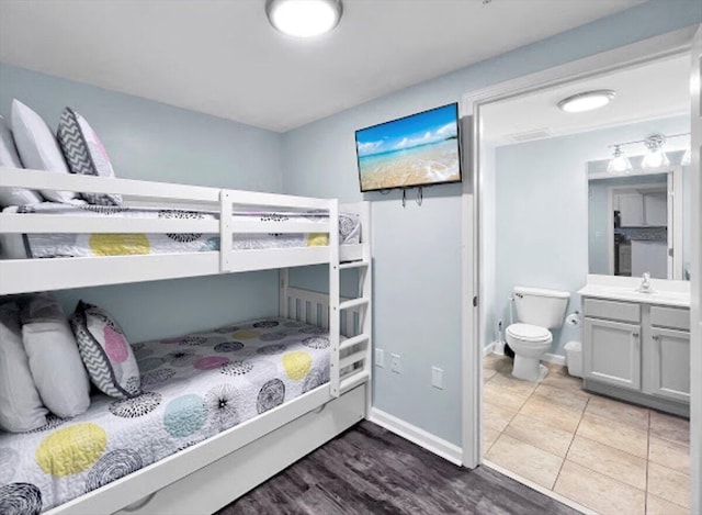 tiled bedroom with connected bathroom and baseboards