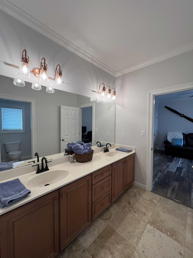 bathroom with vanity, ornamental molding, and toilet