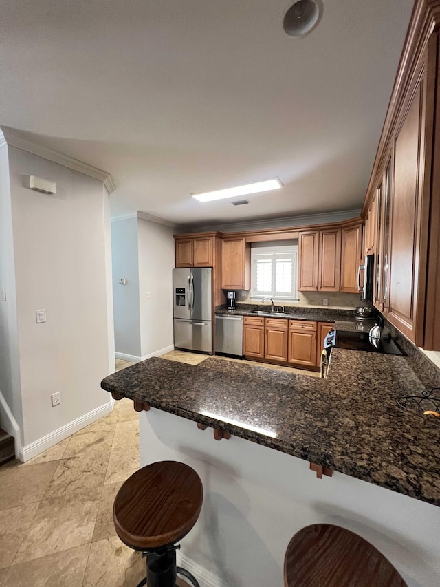 kitchen with a kitchen bar, sink, crown molding, kitchen peninsula, and stainless steel appliances