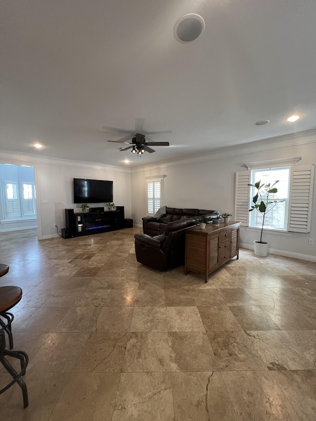 living room with ceiling fan, a healthy amount of sunlight, and ornamental molding