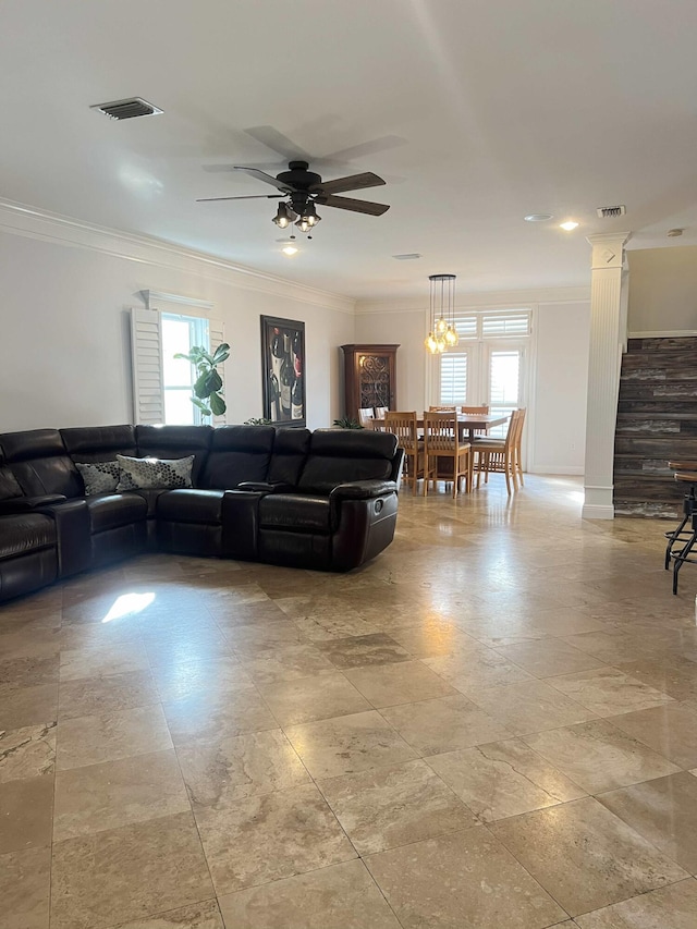 living room featuring a wealth of natural light, ornamental molding, and decorative columns