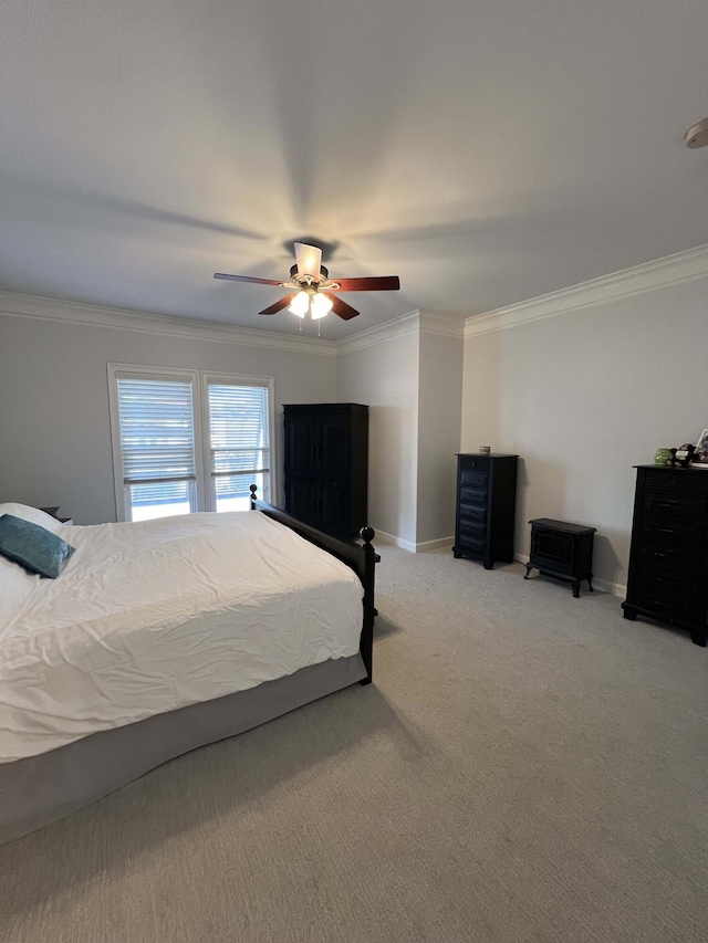 carpeted bedroom with ornamental molding and ceiling fan