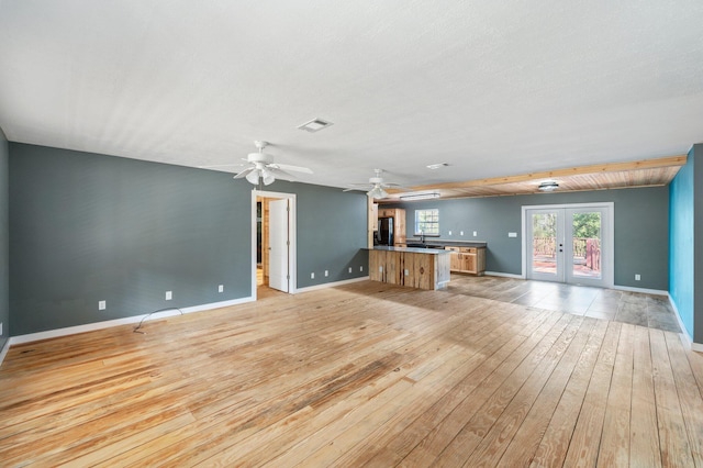 unfurnished living room featuring light hardwood / wood-style flooring, french doors, and ceiling fan