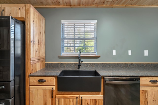 kitchen featuring sink, dark stone counters, light brown cabinetry, and black appliances