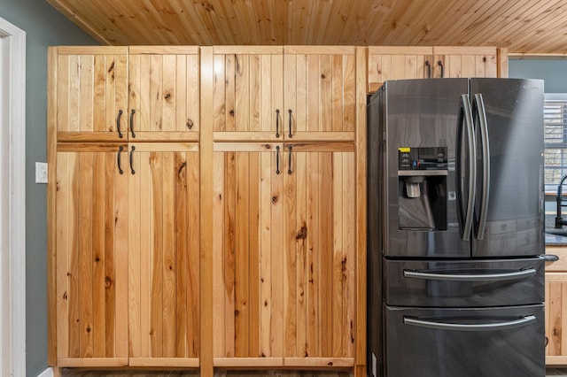 kitchen featuring stainless steel fridge, light brown cabinetry, and wooden ceiling