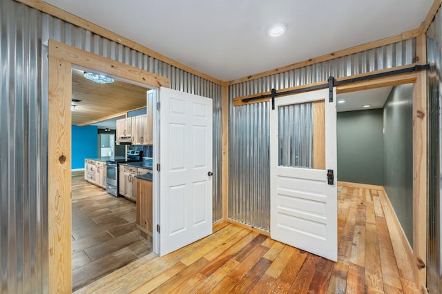 interior space with light hardwood / wood-style floors and a barn door