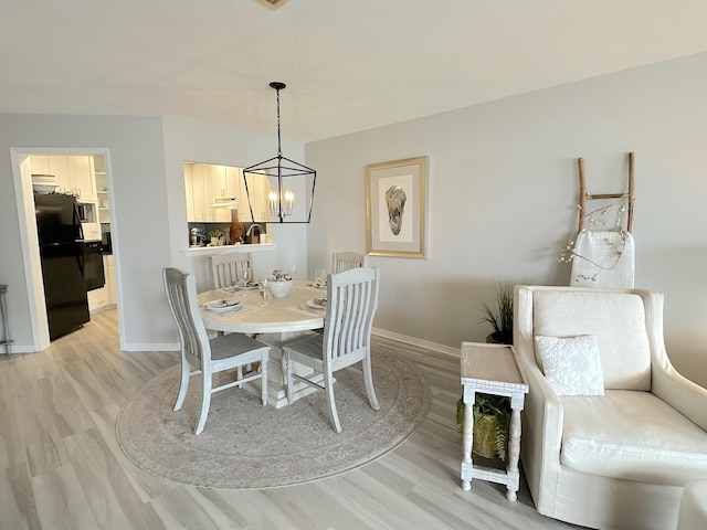 dining space with wood-type flooring and a notable chandelier