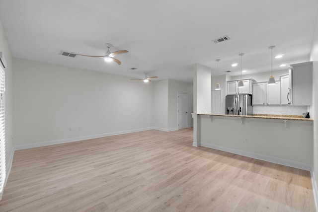 unfurnished living room with light hardwood / wood-style floors and ceiling fan