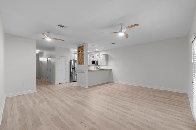 unfurnished living room with ceiling fan and light hardwood / wood-style flooring