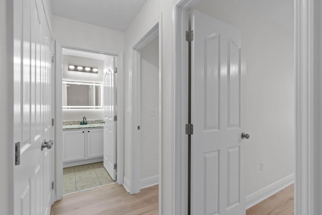 corridor with sink and light hardwood / wood-style floors