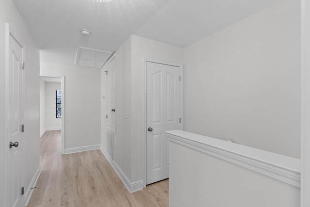 hall featuring a textured ceiling and light wood-type flooring