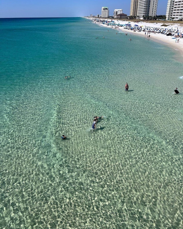 birds eye view of property featuring a water view and a beach view