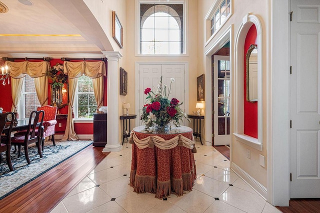 tiled entrance foyer with a high ceiling and ornate columns