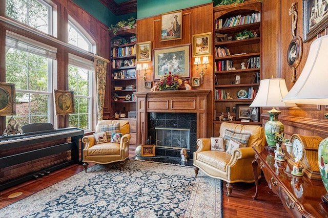 living area featuring dark hardwood / wood-style flooring, built in shelves, and a fireplace