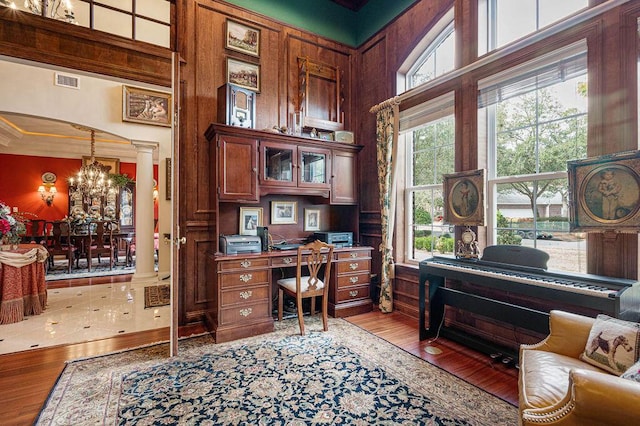 office space featuring a notable chandelier, light hardwood / wood-style flooring, and ornate columns