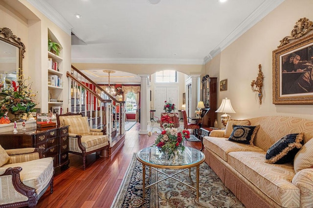 living room featuring ornamental molding, ornate columns, a notable chandelier, and dark hardwood / wood-style flooring