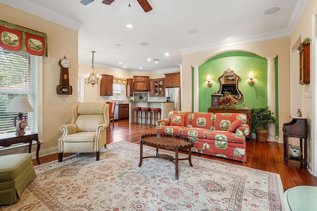 living room with dark wood-type flooring, ornate columns, crown molding, and ceiling fan