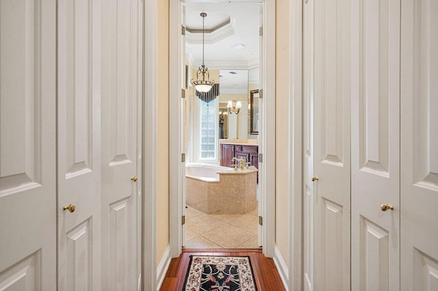 hall featuring a tray ceiling, ornamental molding, and dark hardwood / wood-style flooring